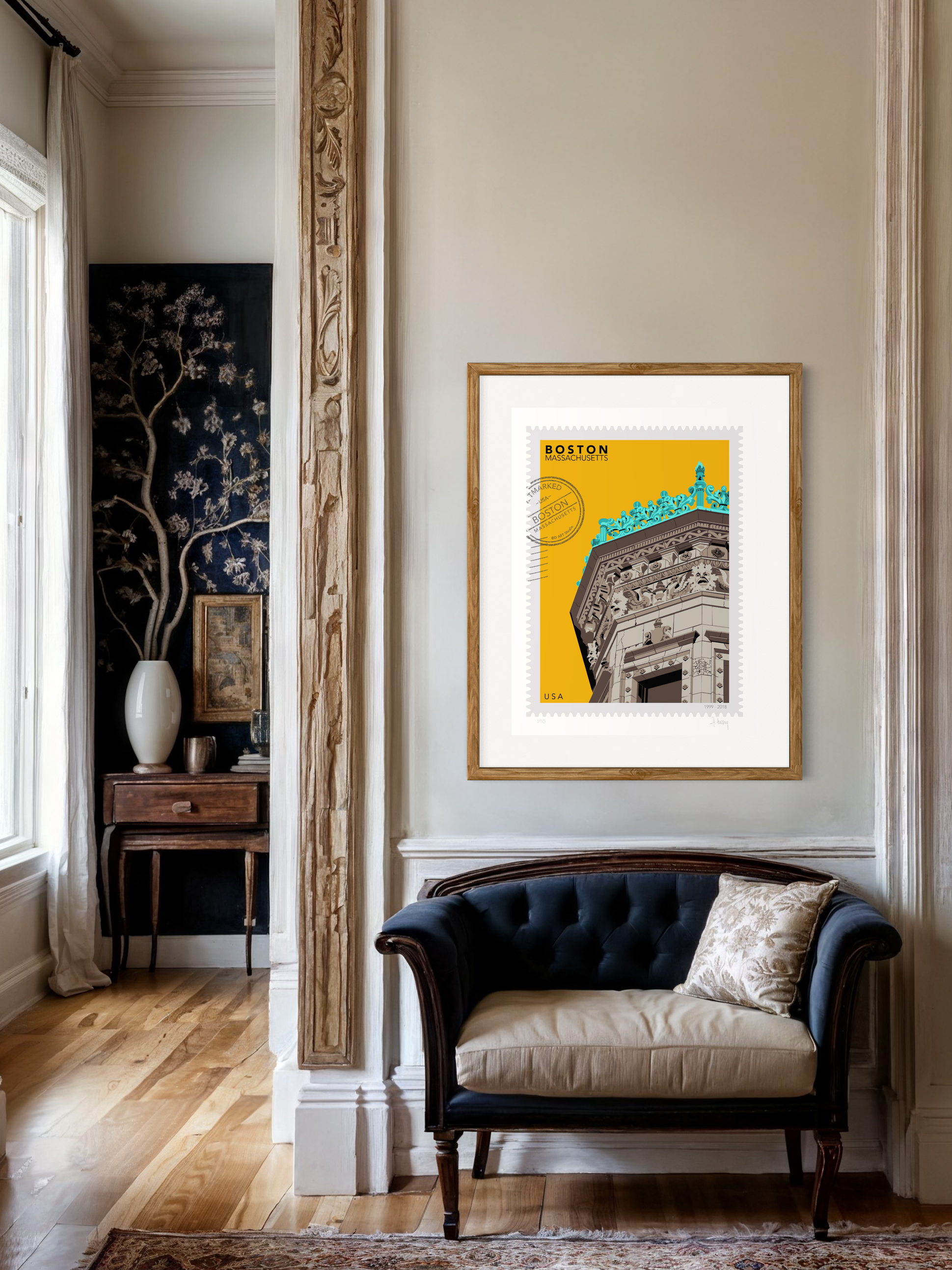 Drawing of the Proctor Building crowned with decorative elements on a yellow background, featuring the text 'Boston, Massachusetts' and 'USA'. Large postage stamp art, postmarked with D ART Studio stamp. Ana Hussey art. Framed on a wall above a black velvet sofa in a stylish room.