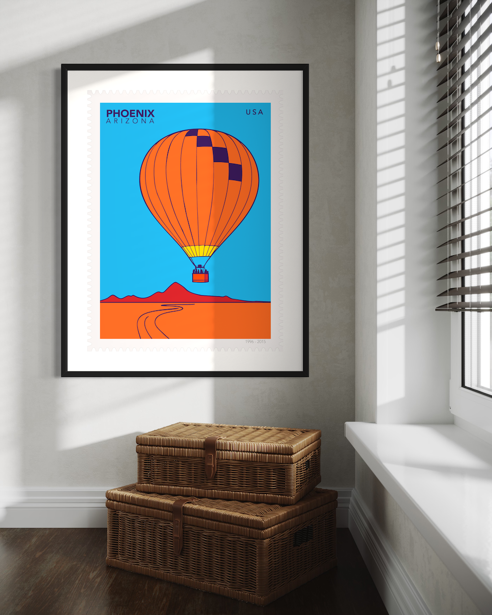Large postage stamp illustration of a hot air balloon over Phoenix, Arizona with a blue sky and orange desert. Framed on the wall by the window.