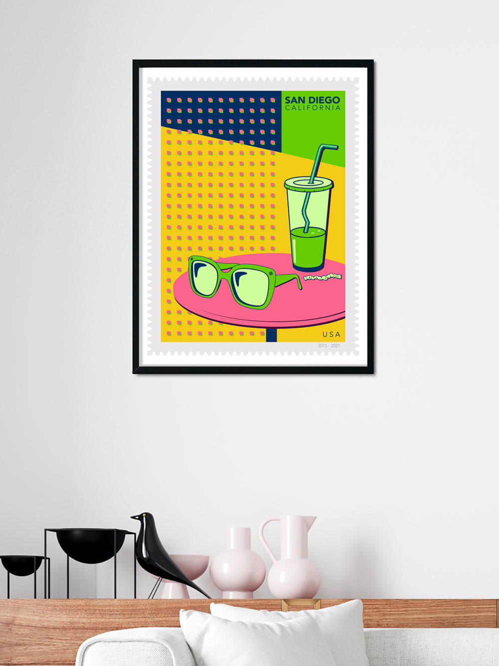 Framed artwork with sunglasses, a drink, and 'San Diego' text on a yellow background.