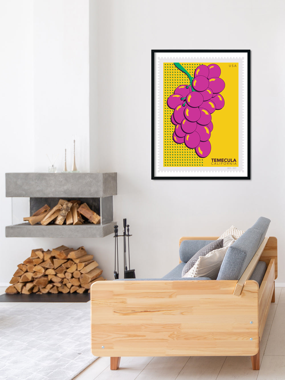 Living room with a wooden sofa, fireplace, and colorful Temecula wine grapes artwork.
