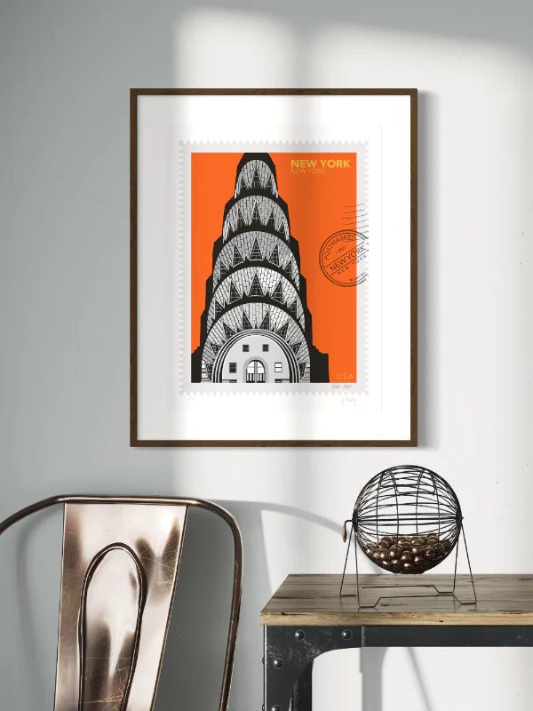 Drawing of the Chrysler Building with geometric patterns on an orange background, in a large size, New York oversized postage stamp. Framed on a wall. Ana Hussey art.
