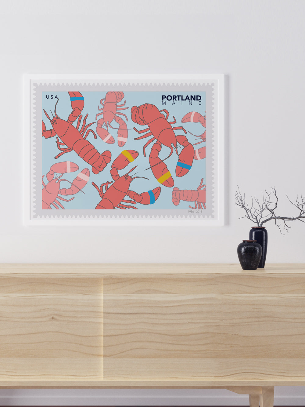 Framed art of illustration of a postage stamp of red lobsters with 'Portland Maine' text on a light blue background.
